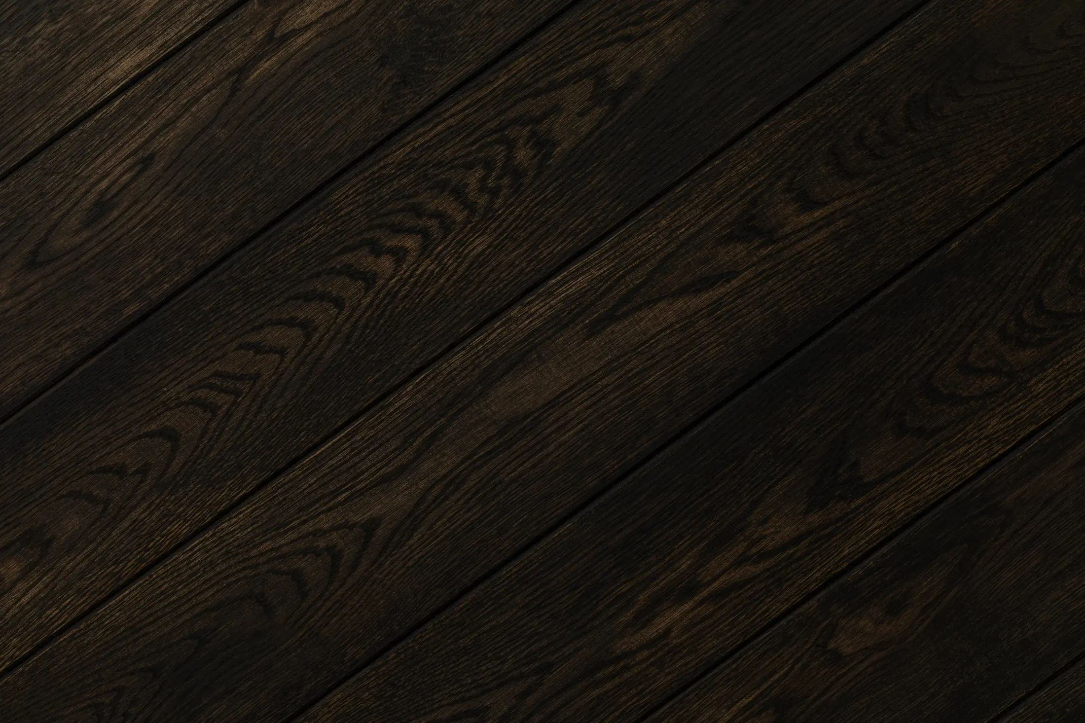 Close up of dark oak plank flooring showing the wood grain and board joins