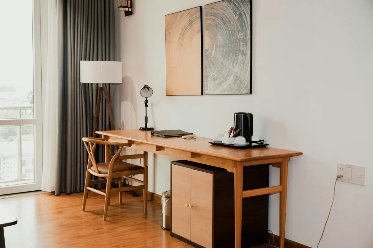 Home office nook with a timber desk and chair on warm oak plank flooring